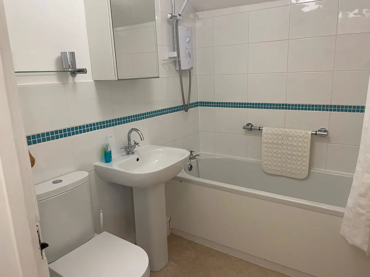 Family bathroom with a bath, shower over the bath and washbasin