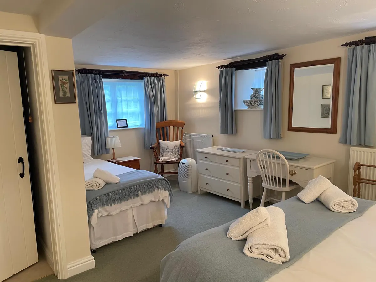Bedroom with a made-up bed, dressing table and folded towels