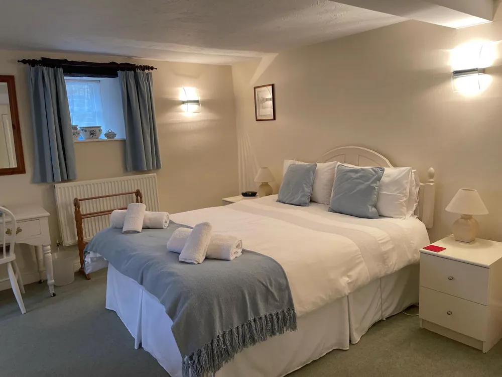 Ground-floor bedroom with a king-size bed dressed in white and blue linen